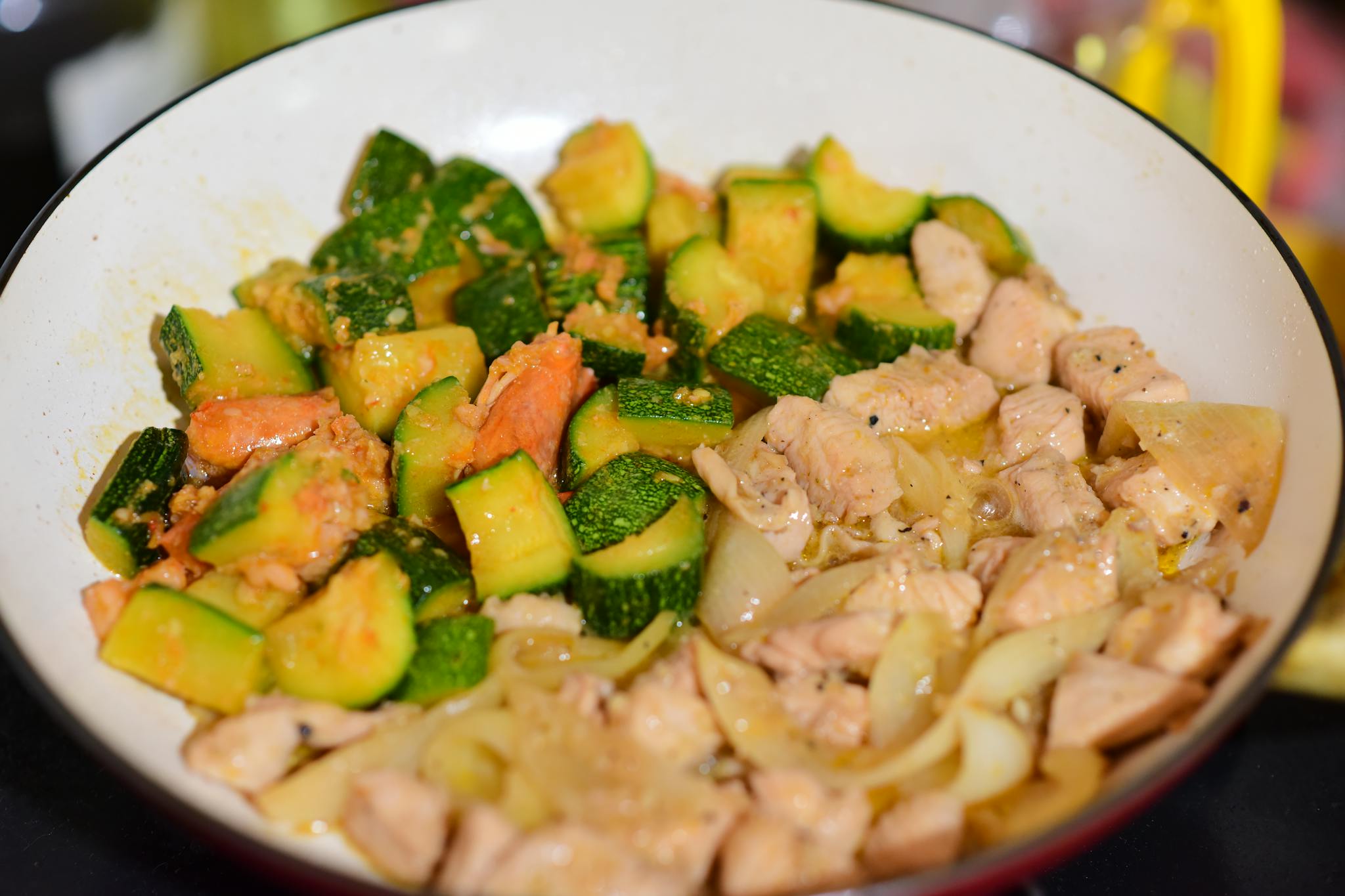 Sautéed chicken and zucchini mix in a pan for a healthy meal.
